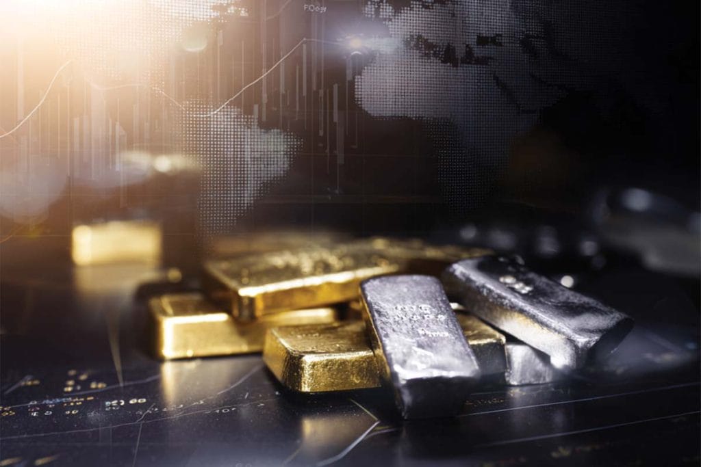 Petits lingots d'or et d'argent posés sur une surface sombre